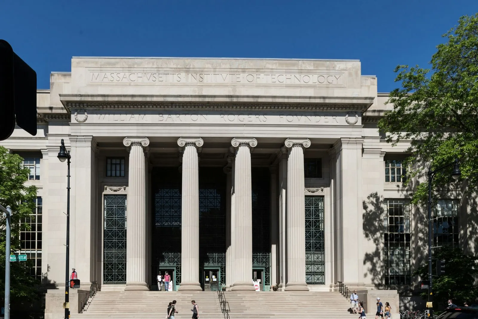 A building with pillars and people coming out and going in